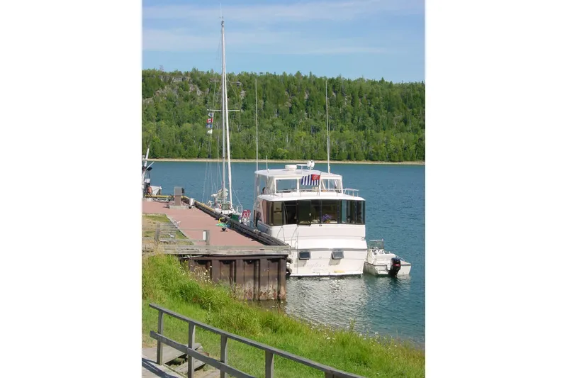 Slide: The Image of 1989 Dyna Craft 45 yacht docked by a scenic, forested shoreline. - 5
