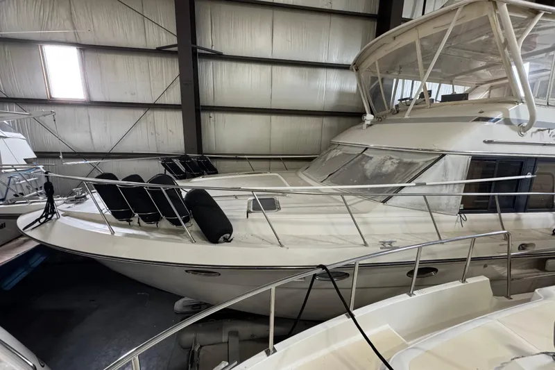 Slide: The Image of 1989 Dyna Craft 45 yacht in indoor storage, featuring sleek design and protective railings. - 57