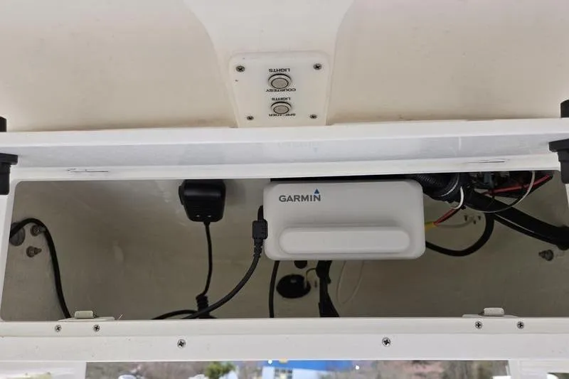 Slide: The Image of 2024 Sea Hunt Ultra 234 boat electronics compartment with Garmin device and wiring. - 12