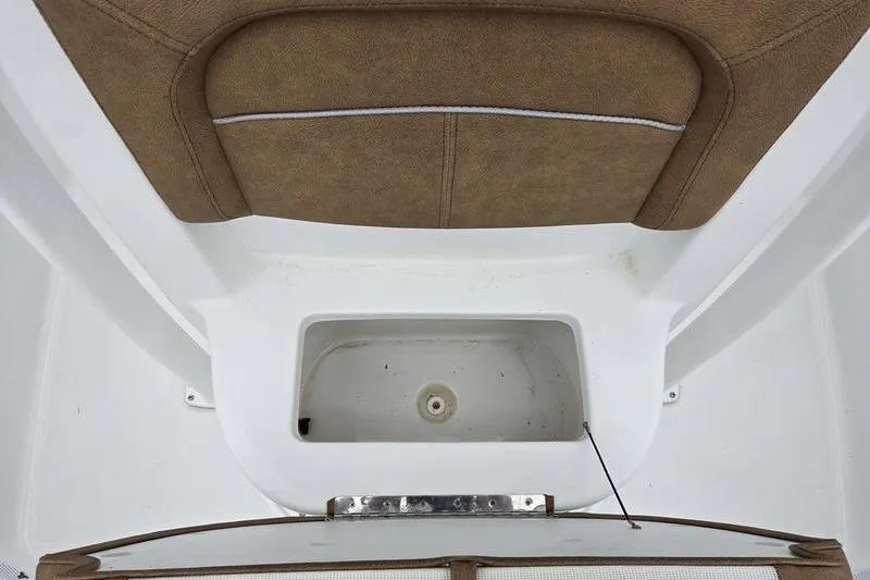 Slide: The Image of 2024 Sea Hunt Ultra 234 boat interior with brown cushioned seating and storage compartment. - 13