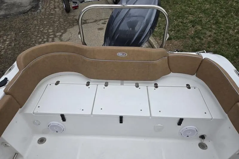 Slide: The Image of 2024 Sea Hunt Ultra 234 boat interior with tan seating and storage compartments. - 14