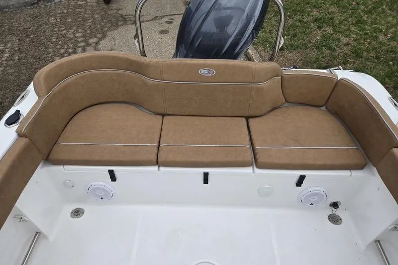 Slide: The Image of 2024 Sea Hunt Ultra 234 boat with tan cushioned seating and white deck. - 16