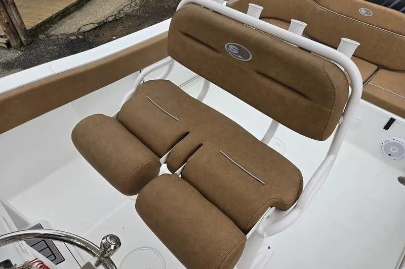 Slide: The Image of 2024 Sea Hunt Ultra 234 boat with tan cushioned seating and white frame. - 17
