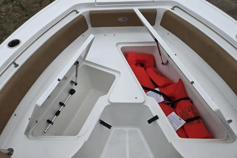 Slide: The Image of 2024 Sea Hunt Ultra 234 boat storage compartments with life jackets. - 6