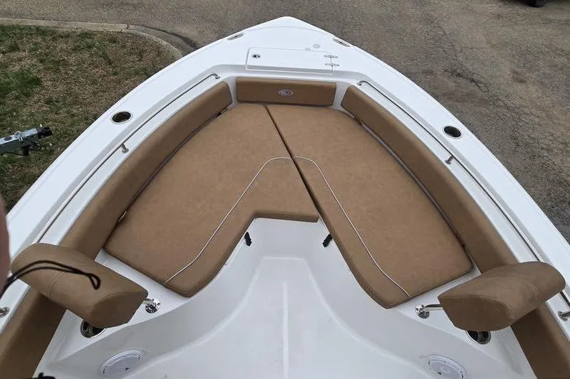 Slide: The Image of 2024 Sea Hunt Ultra 234 boat with tan cushioned seating in the bow area. - 9