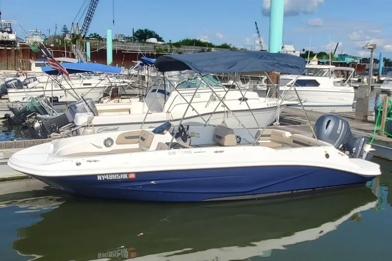 The Image of 2023 Hurricane SunDeck Sport 185 OB boat docked at marina, blue and white design. - 2