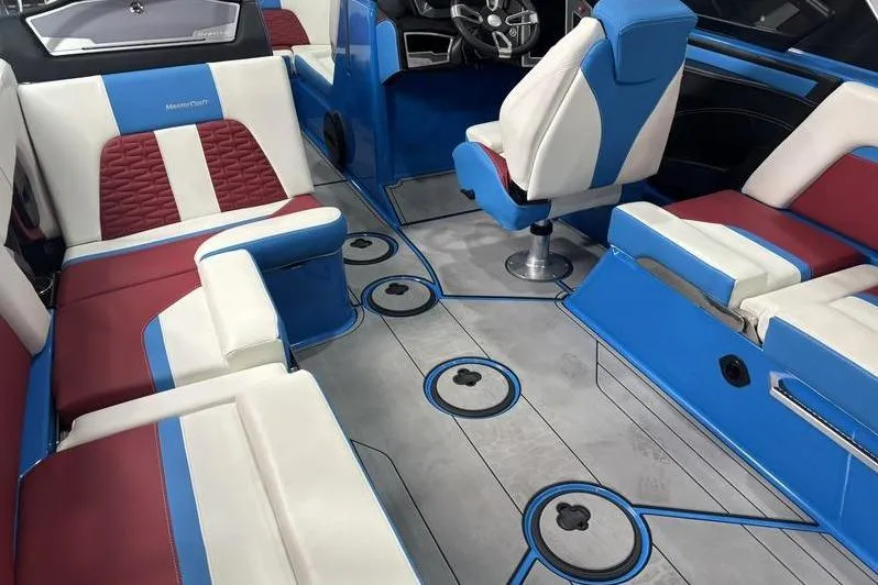 Slide: The Image of 2024 MasterCraft X24 boat interior with blue, red, and white seating and modern design. - 11