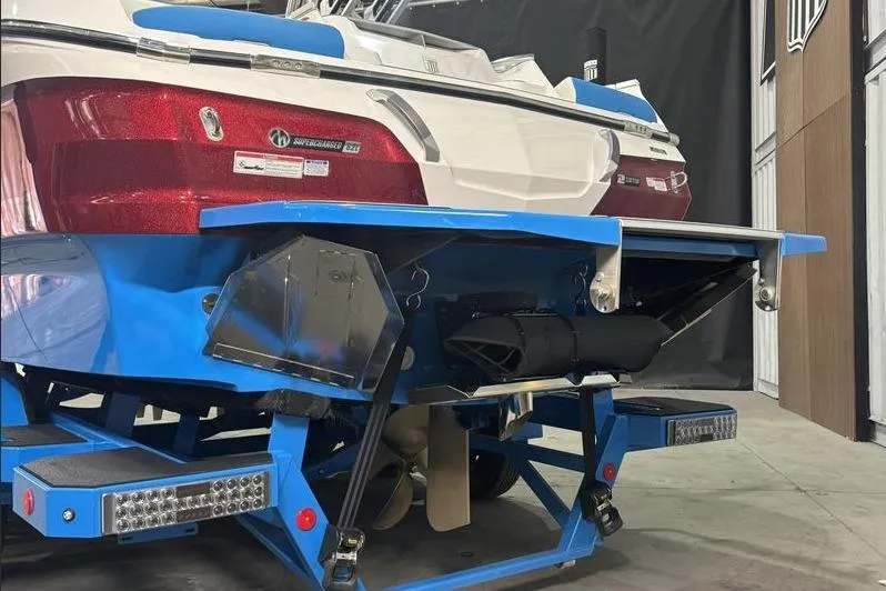 Slide: The Image of 2024 MasterCraft X24 boat rear view, showcasing blue hull and advanced features. - 14