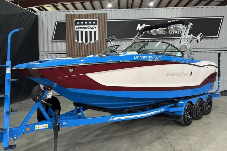 Slide: The Image of 2024 MasterCraft X24 boat on a blue trailer in a showroom. - 3