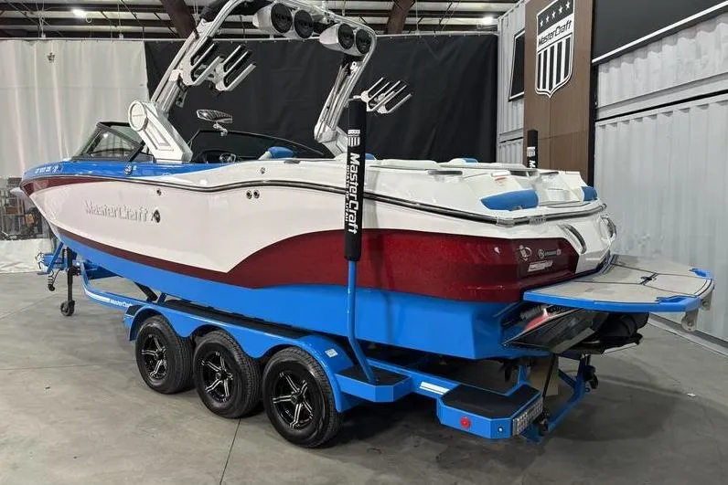 Slide: The Image of 2024 MasterCraft X24 boat on a blue trailer in a showroom. - 5