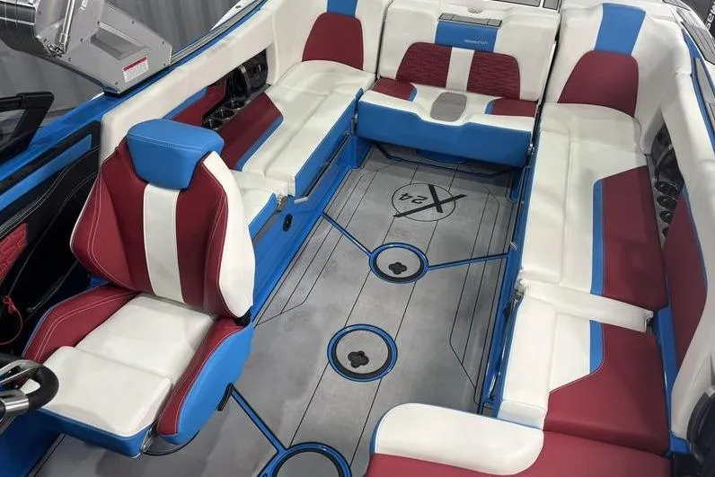 Slide: The Image of 2024 MasterCraft X24 boat interior with red, white, and blue seating and sleek design. - 6