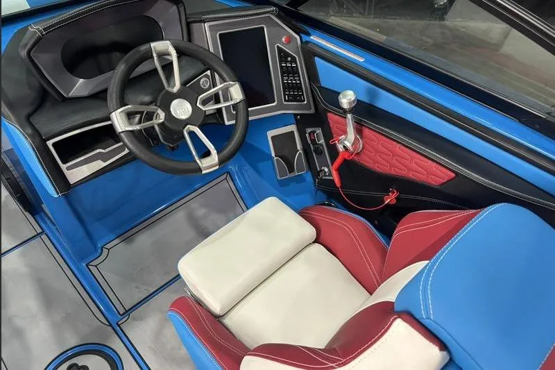 Slide: The Image of 2024 MasterCraft X24 boat interior with blue, red, and white seating, modern steering, and control panel. - 8