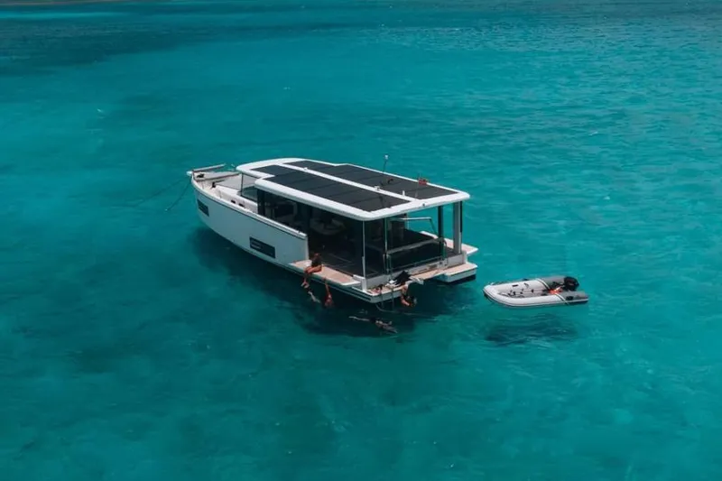 Slide: The Image of Manufacturer Provided Image: 2026 Jeanneau Sea Loft 480 yacht anchored in clear turquoise water with a small dinghy. - 2