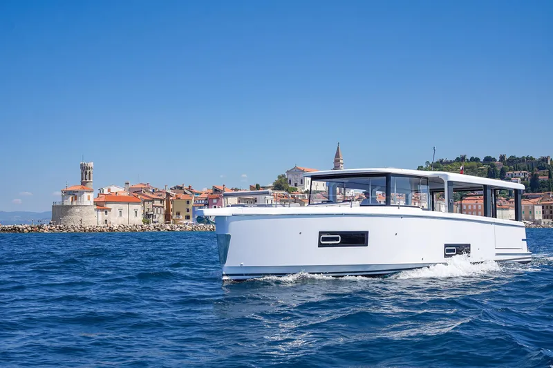 Slide: The Image of 2026 Jeanneau Sea Loft 480 cruising near coastal town with historic architecture. - 4