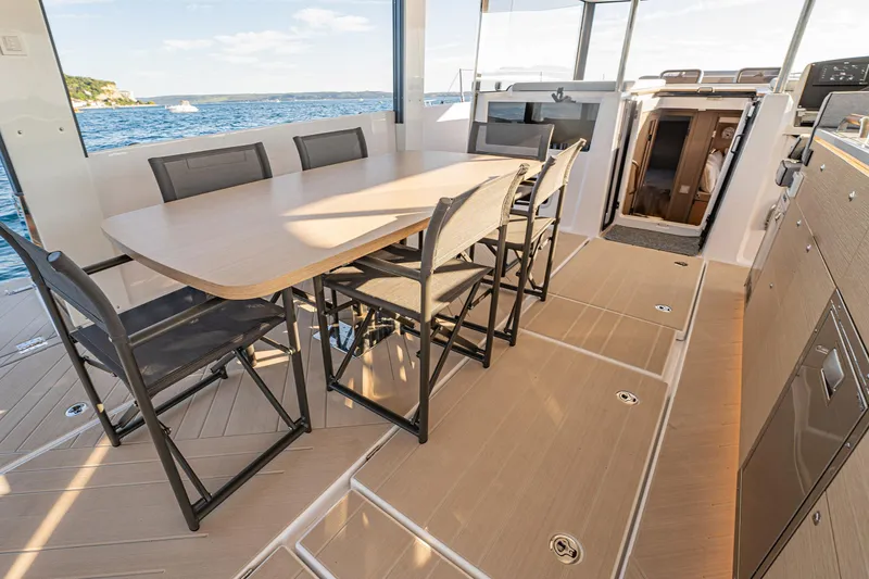 Slide: The Image of 2026 Jeanneau Sea Loft 480 yacht interior with dining area and ocean view. - 9