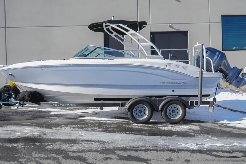 The Image of 2023 Chaparral 21 SSi Ski & Fish OB boat on trailer, parked outdoors. - 0