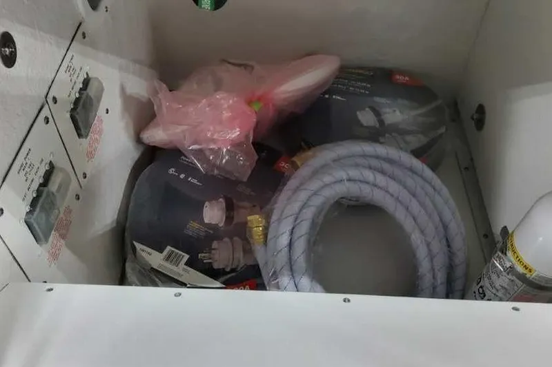 Slide: The Image of Storage compartment in 2023 Formula 380 Super Sport Crossover OB with hoses and accessories. - 10