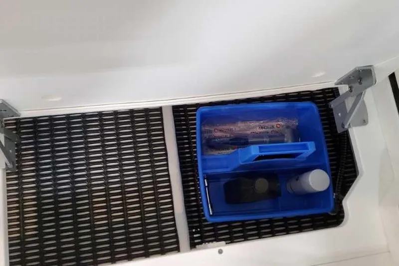 Slide: The Image of Storage compartment in 2023 Formula 380 Super Sport Crossover OB with blue organizer tray. - 22