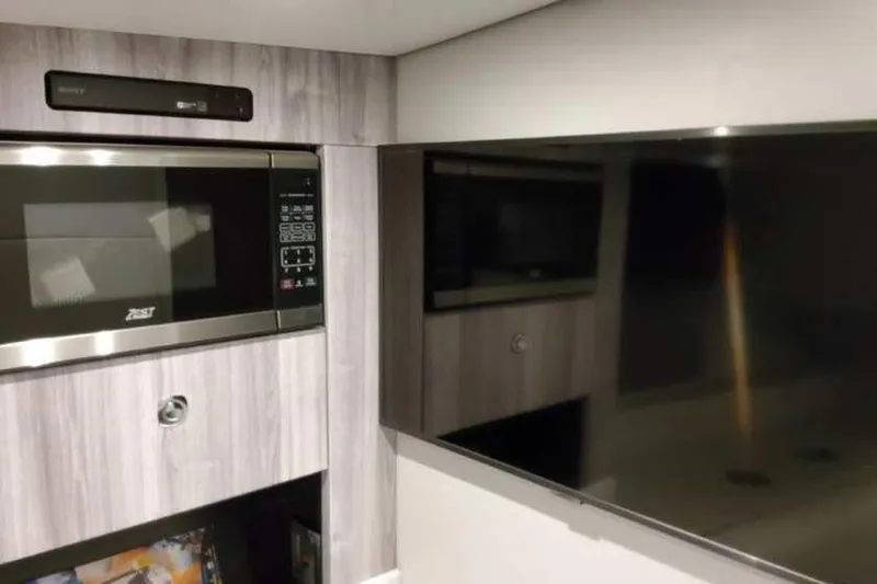 Slide: The Image of 2023 Formula 380 Super Sport Crossover OB interior with microwave and TV setup. - 63