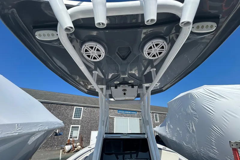 Slide: The Image of 2020 Tidewater 232 LXF boat with T-top speakers and rod holders, docked outdoors. - 10