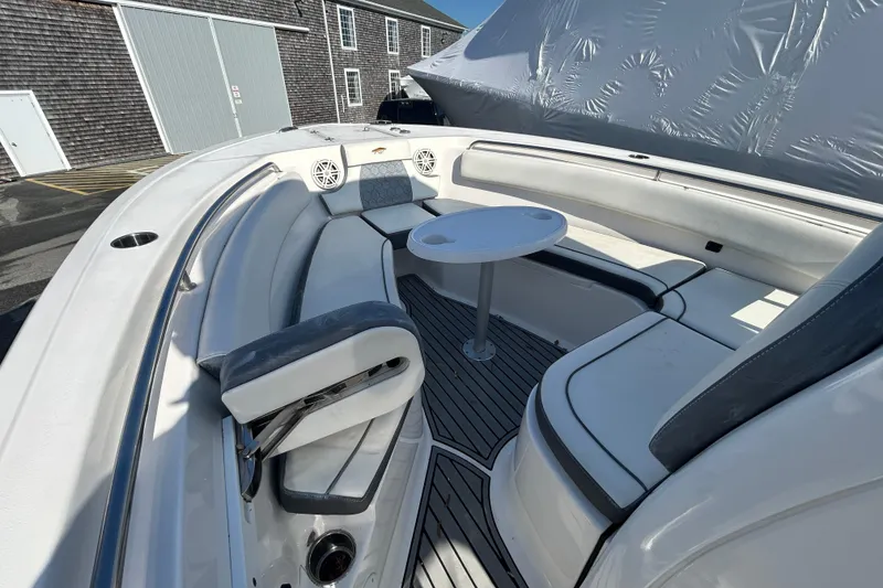 Slide: The Image of 2020 Tidewater 232 LXF boat interior with seating and table, docked outdoors. - 18