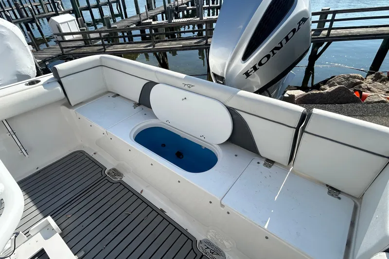 Slide: The Image of 2020 Tidewater 232 LXF boat interior with Honda engine, docked by the water. - 24