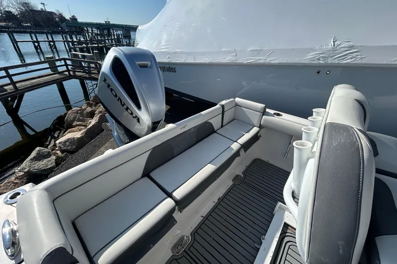 Slide: The Image of 2020 Tidewater 232 LXF boat with Honda outboard motor, docked near a marina. - 3