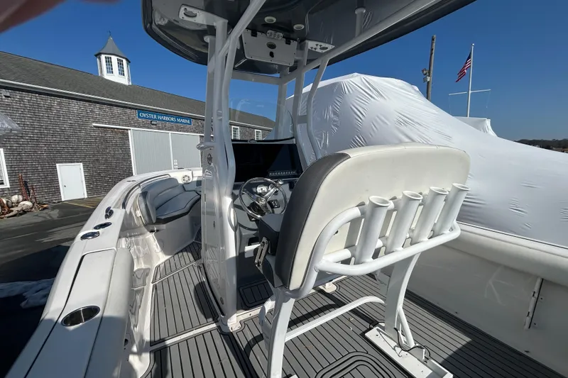 Slide: The Image of 2020 Tidewater 232 LXF boat interior with helm, rod holders, and seating at Oyster Harbors Marine. - 5