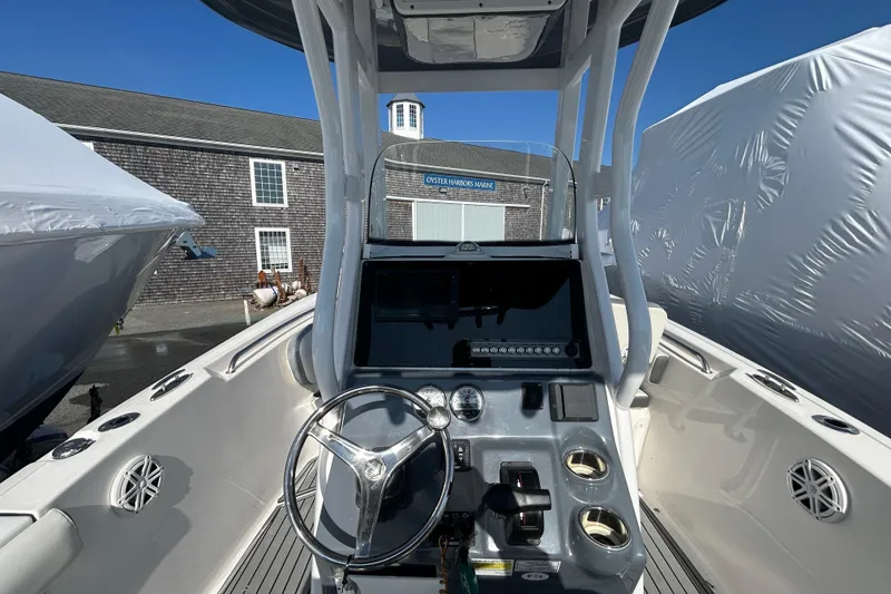 Slide: The Image of 2020 Tidewater 232 LXF boat dashboard with steering wheel and controls, docked at marina. - 6