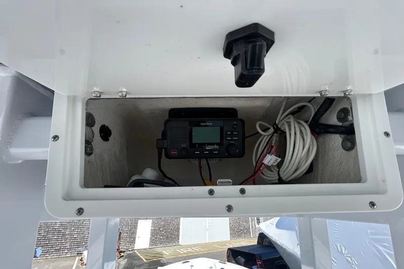Slide: The Image of 2020 Tidewater 232 LXF boat electronics compartment with Garmin device and cables. - 9