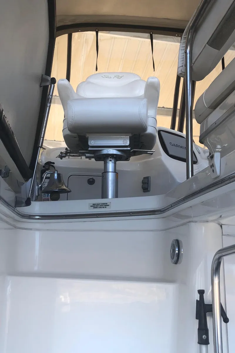 Slide: The Image of 2001 Sea Ray 400 Sedan Bridge helm with white captain's chair and controls. - 19