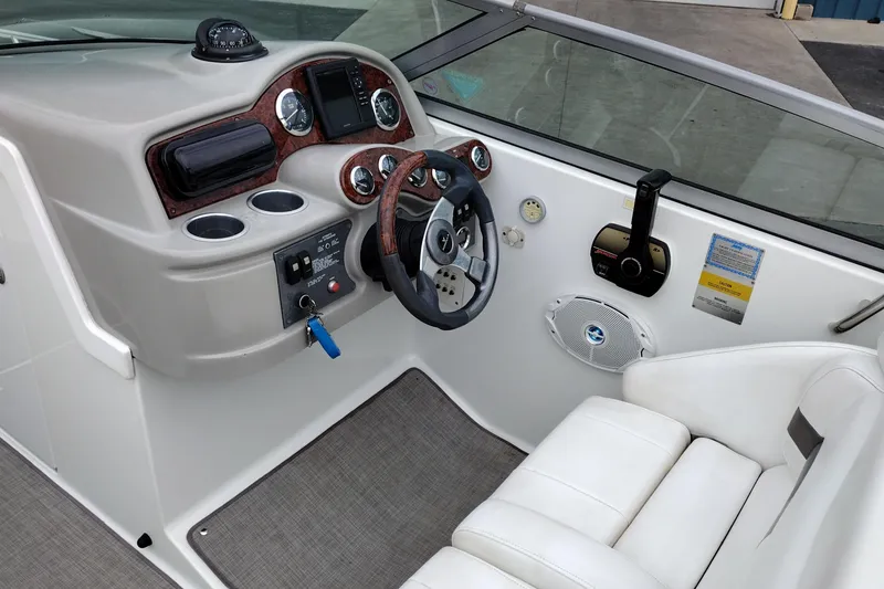Slide: The Image of 2004 Formula 260 Bowrider cockpit with steering wheel, gauges, and white seating. - 12
