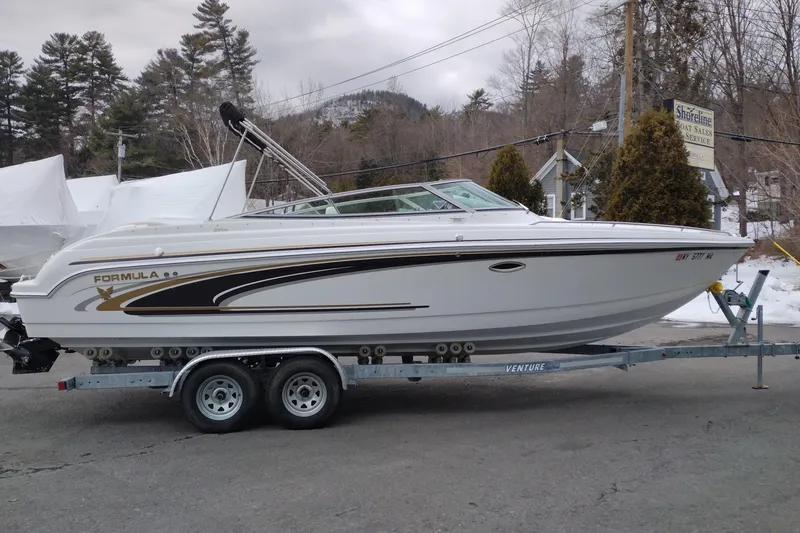 Slide: The Image of 2004 Formula 260 Bowrider boat on trailer, parked outdoors in a wooded area. - 4