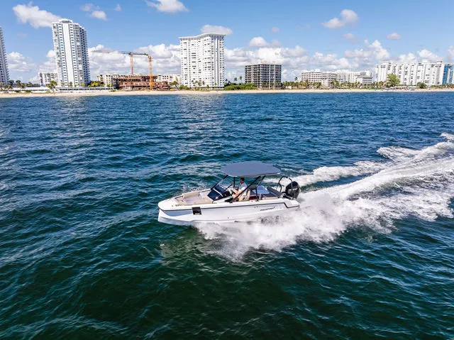 Slide: The Image of 2022 Axopar 22 T-Top boat interior with gray seating and storage compartment. - 13