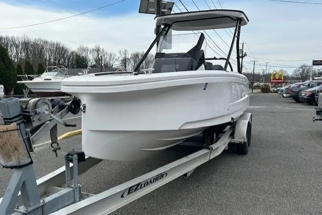 Slide: The Image of 2022 Axopar 22 T-Top boat on trailer, parked outdoors. - 2