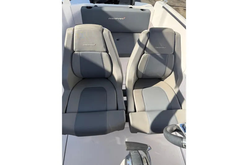 Slide: The Image of 2022 Axopar 22 T-Top boat interior with two gray seats and steering wheel. - 8