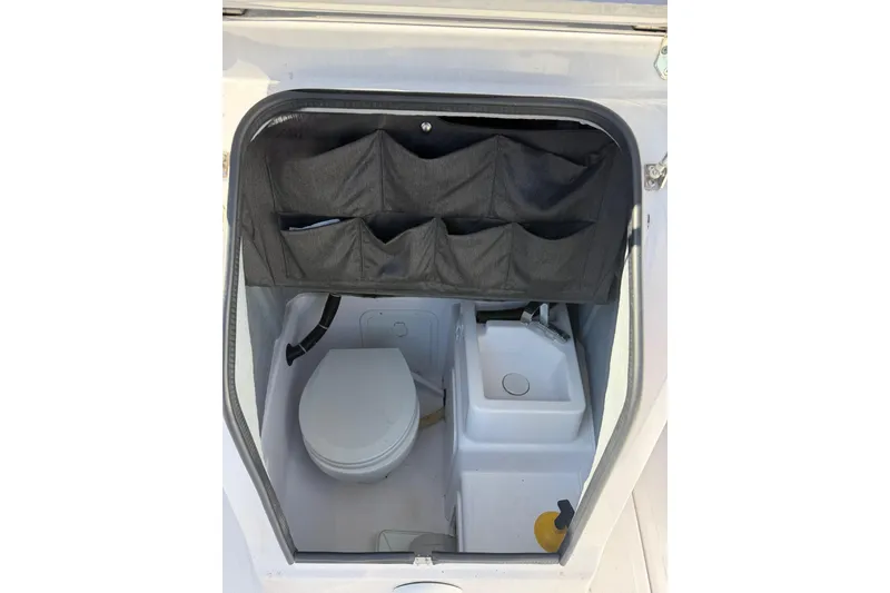 Slide: The Image of 2022 Axopar 22 T-Top boat interior with toilet and storage compartments. - 9
