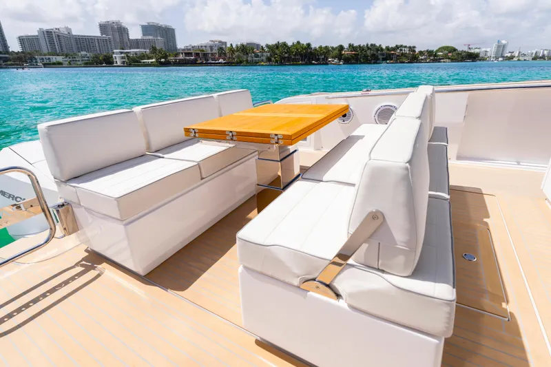 Slide: The Image of Luxury seating area on 2025 Pardo Yachts P38, featuring elegant white cushions and wooden table. - 19