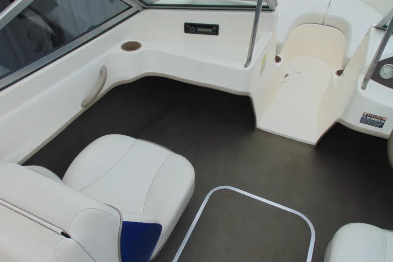 Slide: The Image of 2004 Bayliner 1750 Capri interior with white seating and dashboard view. - 10