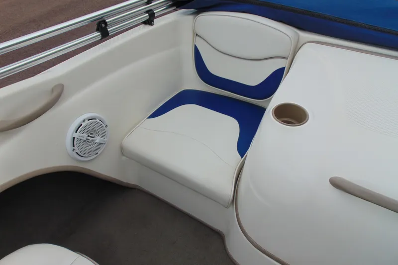 Slide: The Image of 2004 Bayliner 1750 Capri boat interior with blue and white seating, cup holder, and speaker. - 14