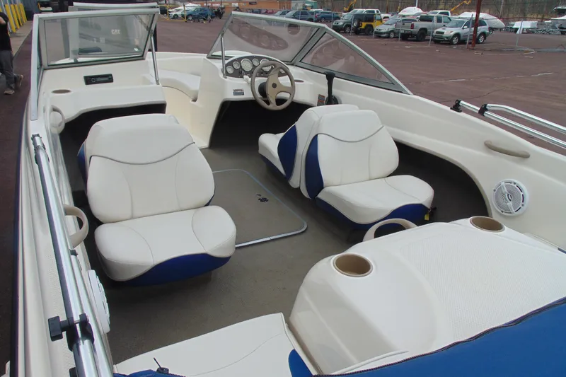 Slide: The Image of 2004 Bayliner 1750 Capri boat interior with white and blue seating, steering wheel, and dashboard. - 6