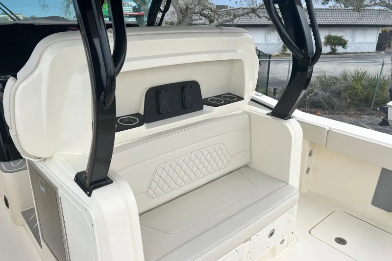 Slide: The Image of 2026 Scout 377 LXF boat interior with cushioned seating and cup holders. - 10
