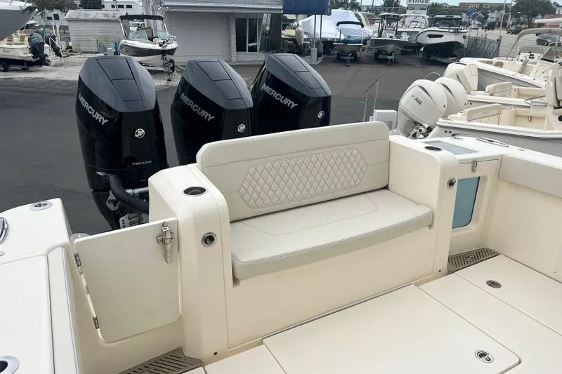 Slide: The Image of 2026 Scout 377 LXF boat with triple Mercury Verado engines and cushioned seating. - 11