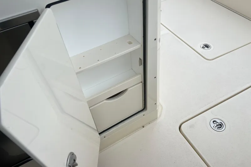 Slide: The Image of Open storage compartment on 2026 Scout 377 LXF boat deck. - 16