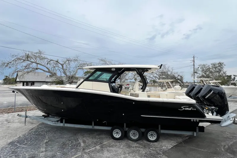 Slide: The Image of 2026 Scout 377 LXF boat with triple Mercury engines on trailer. - 4