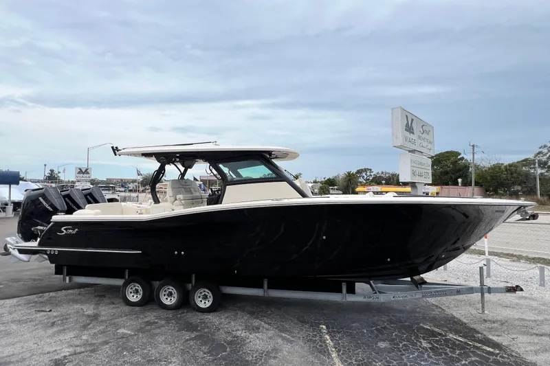 Slide: The Image of 2026 Scout 377 LXF boat on trailer, black hull, outdoor display. - 6