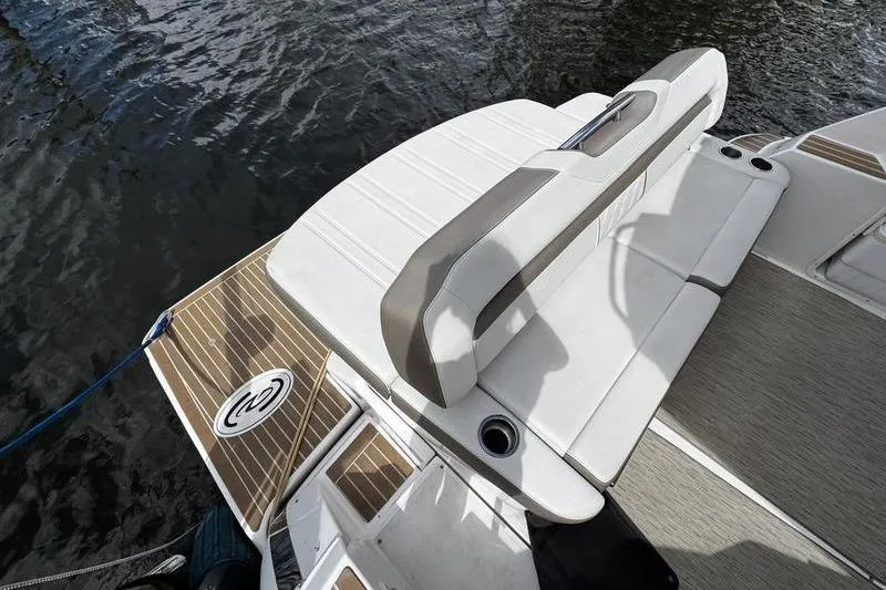 Slide: The Image of 2018 Regal 35 Sport Coupe boat with white seating and teak deck, docked on water. - 10