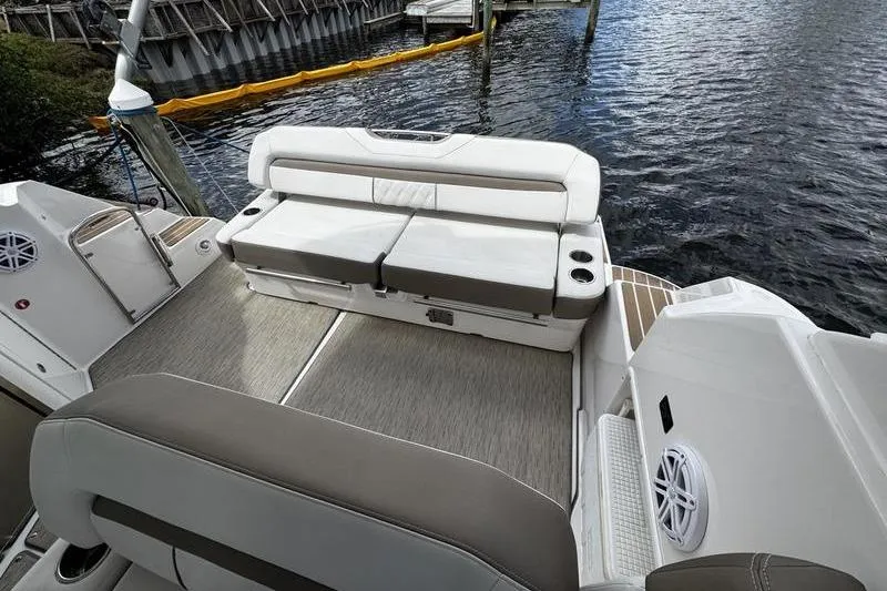 Slide: The Image of 2018 Regal 35 Sport Coupe boat interior with cushioned seating and water view. - 12