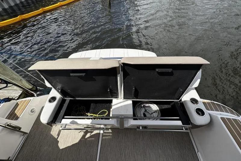 Slide: The Image of 2018 Regal 35 Sport Coupe boat with open storage compartments by the water. - 13