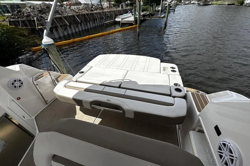 Slide: The Image of 2018 Regal 35 Sport Coupe boat with spacious sun deck by the water. - 15